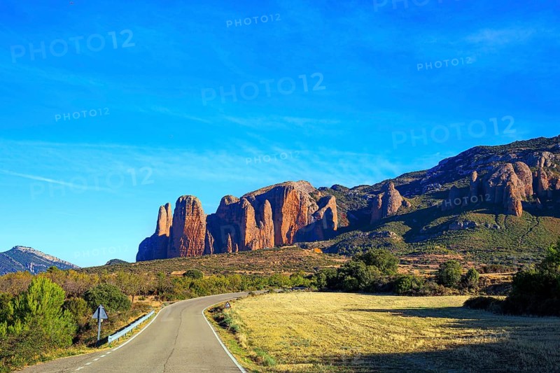 The magnificent Mallets of Riglos is a conglomerate of rock formations. Scenic paved highway. Romantic trip to Spain, Hoya de Huesca. The foothills of the Pyrenees. Sunny afternoon