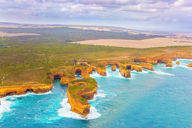 Aerial view. Helicopter flight over the scenic Pacific coastline. Australia. The Twelve Apostles are a group of limestone rocks in the Pacific Ocean near the coast. Great Ocean Road