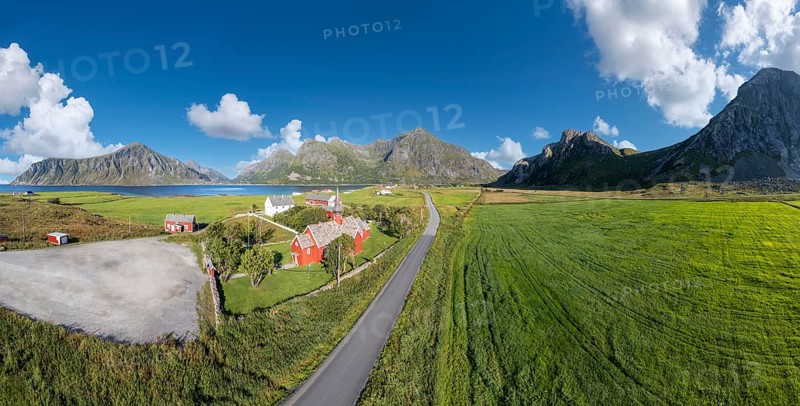 Aerial view of Flakstad church. In the background the peaks of the mountains Hustinden, Digertinden, Blekktinden and Flakstadtinden, Flakstad, Lofoten, Norway
