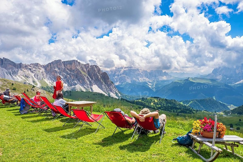Hikers resting in deckchairs with a beautiful view in the Alps