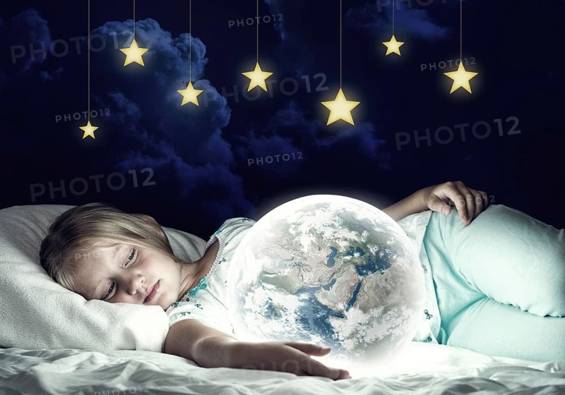 Cute girl in bed and looking at Earth planet. Elements of this image are furnished by NASA