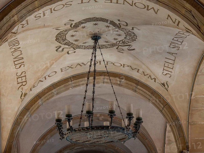 Decorated ceiling with Latin lettering and large chandelier, montserrat, spain