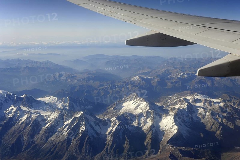Silver wing and snow, aeroplane flies over the Swiss Alps, Switzerland