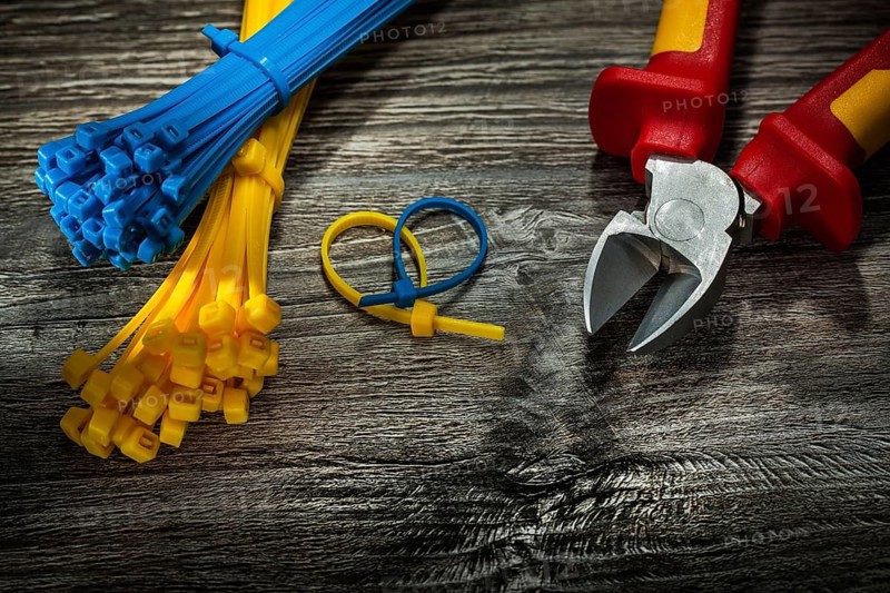 Plastic cables cutting pliers on vintage wooden board