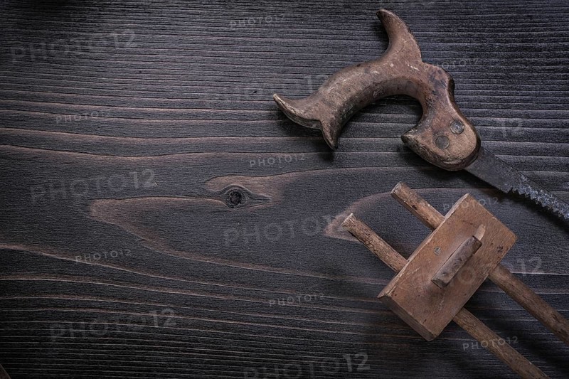 Rusty hand saw marking gauge on wooden board copy space