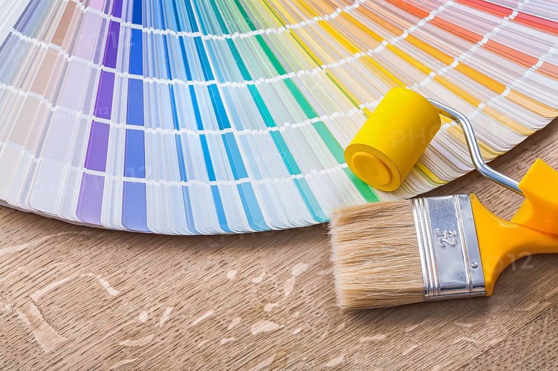 Paint brush roller and color palette on wood board