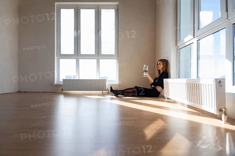 Beautiful elegant girl sits on the floor in a large light room with stained glass windows