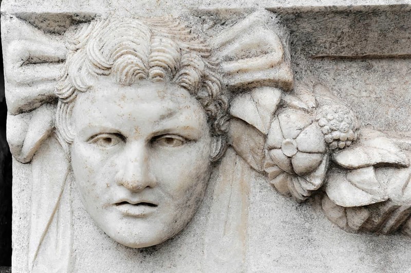 Excavation site site of the ancient city of Aphrodisias, today's city of Geyre, Karacasu, Aydin, Western Turkey, Turkey, Asia, Detail of an ancient stone sculpture with a face and ornaments, city of Aphrodisias, Caria, Aydin province