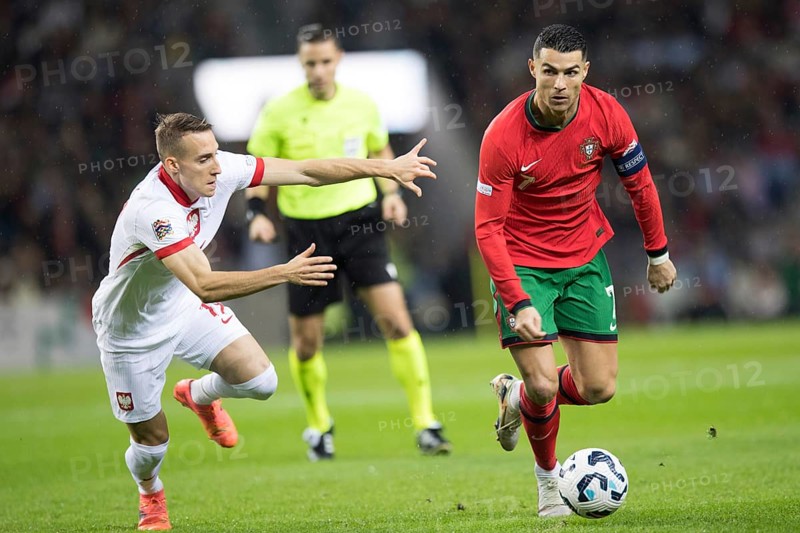Football match, captain Cristiano RONALDO CR7 Portugal on the ball on the right in a duel with Dominik MARCZUK Poland, who is about to lose his balance and still tries to interfere with him, Estadio do Dragao, Porto, Portugal