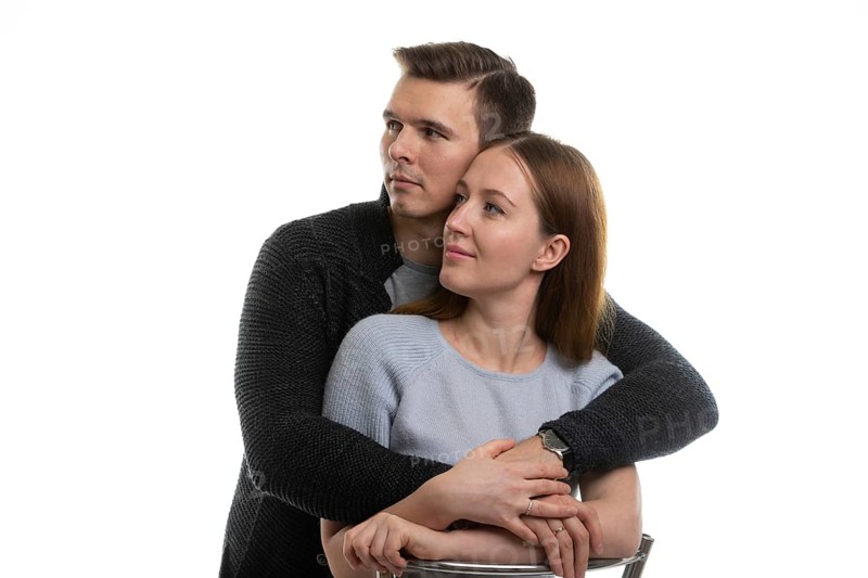 Portrait of a young couple looking to the left, a white background