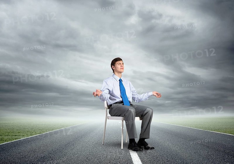 Businessman sitting on an office chair, meditation and calmness