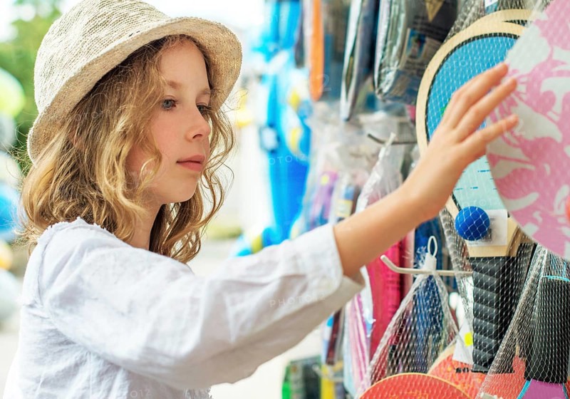 Little girl is choosing table tennis racket for vacations