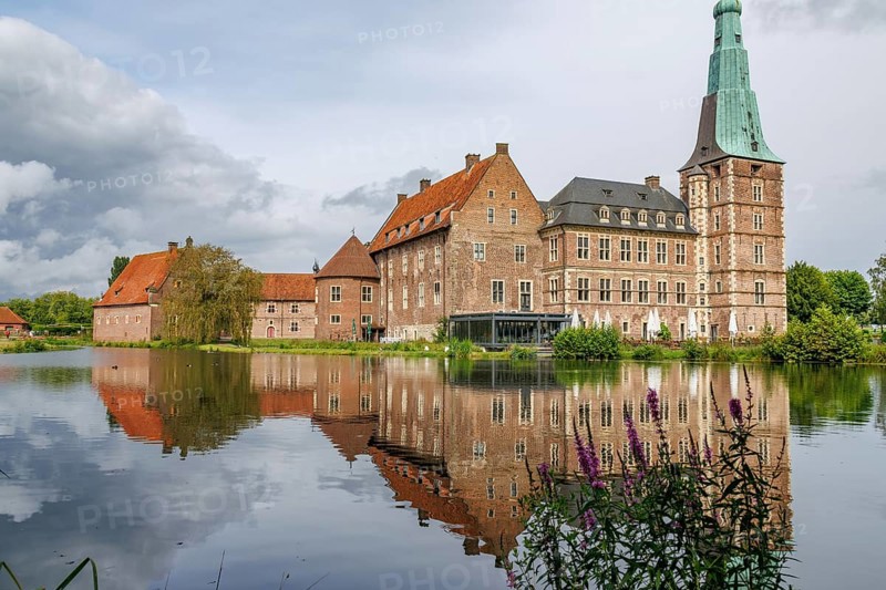 An old castle with a striking tower, reflected in a calm lake, Raesfeld, westphalia, germany