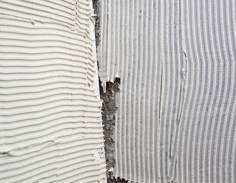 Construction notched trowel mortar shape on big tile back side