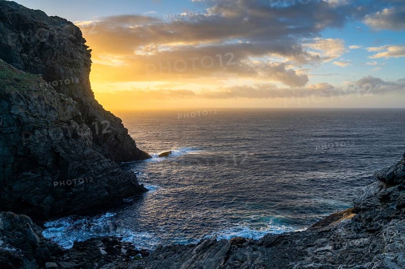 Long exposure sunset seascape with rocks and reef at Capo Falcone in Sardinia