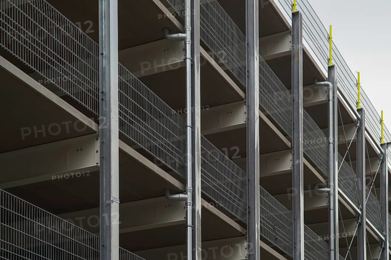 Modern parking garage levels with metal grid railing and support structure