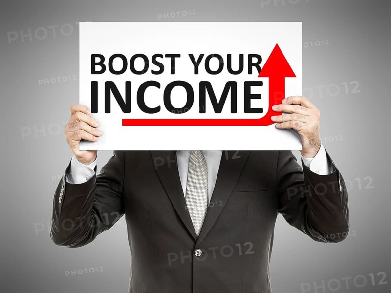 A business man holding a paper in front of his face with the text boost your income