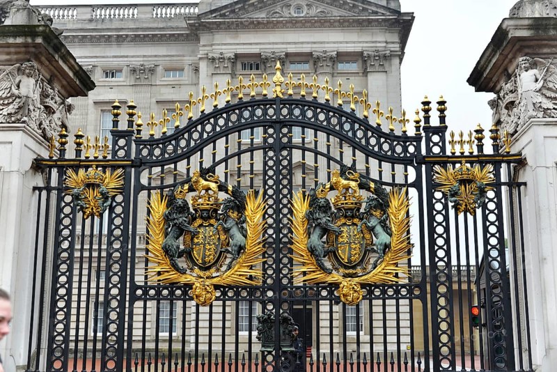 Royal coat of arms on Tor tor, Buckingham Palace, London, London region, England, United Kingdom, Europe, Magnificent metal gate with golden decorations and coat of arms in front of historic building