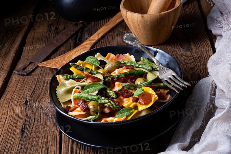 Pasta salad with green asparagus, olives and Parma ham