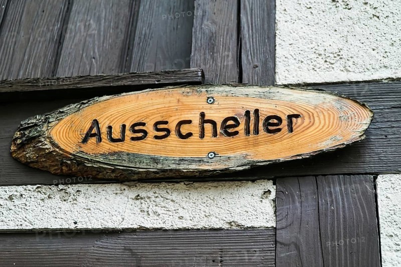 Wooden sign with Ausscheller lettering on a wooden beam