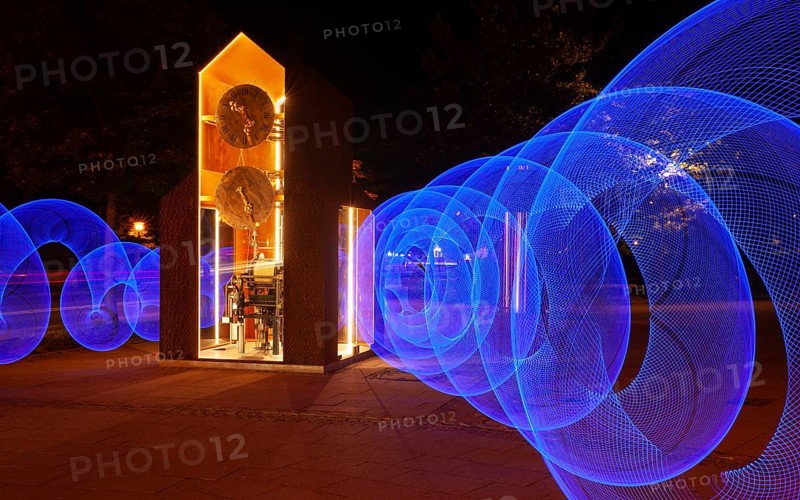 Blue light circles created with LED lights encircle an artistic large clock, Lightpaniting, Mindelheim, Unterallgäu, Bavaria, Germany
