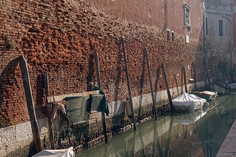 The outer wall of Arsenale: the old brick wall with moorings for small boats