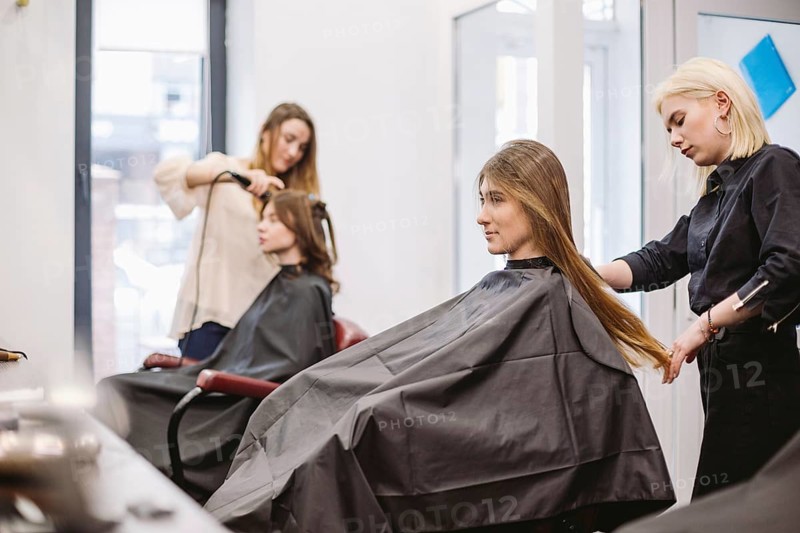 Beautiful woman combing wet hair. stylist brushing woman hair in salon. Hairdresser Serving Customer. Professional Young Hairdresser Working With Comb. hair care concept. Hairdresser Combing Wet Hair