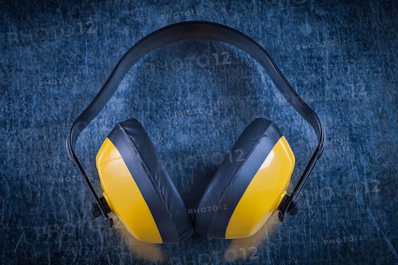 Noise reduction earmuffs on metallic surface construction concept