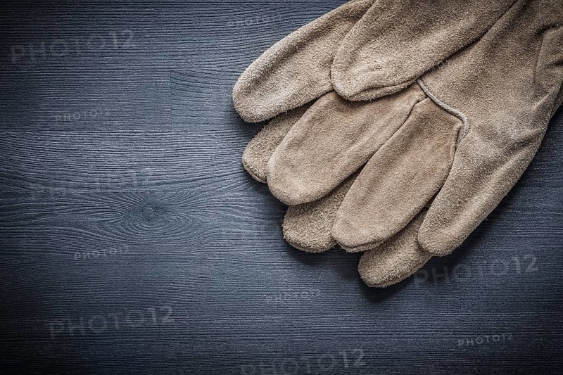 Leather working gloves on dark board