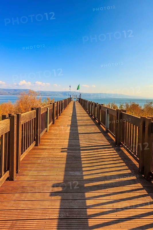 Wooden pier leading to the famous Sea of Galilee. Sunset on the lake of Kinneret