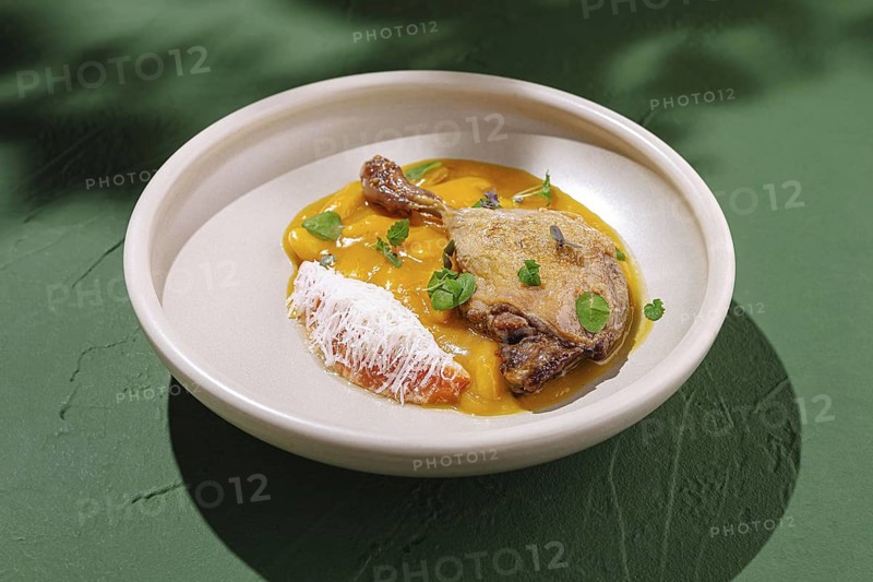 Food, This dish showcases duck breast elegantly arranged on a plate accompanied by a colorful mango puree and fresh herb garnishes. The presentation highlights culinary artistry