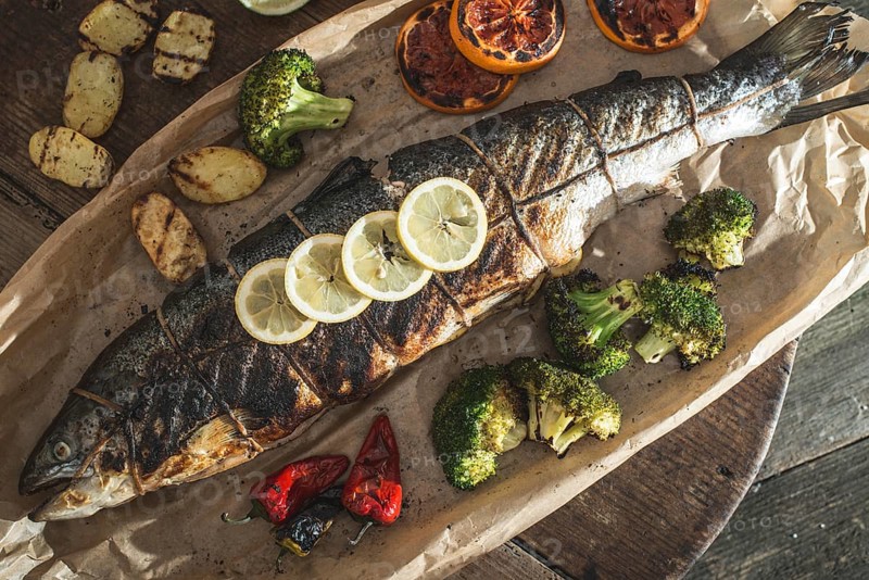 Roasted salmon and vegetables on vintage wooden table
