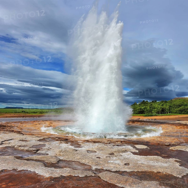 Iceland in the summer. Gushing geyser Strokkur. High column of hot water and steam from the crater of the geyser