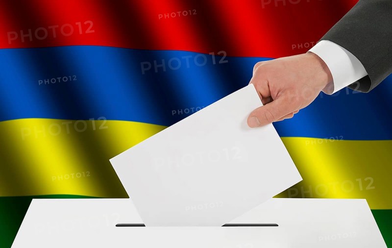 The Mauritius flag and the hand with the bulletin about the ballot box