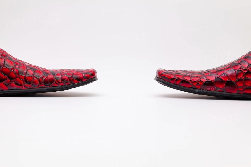 Detail of men's red shoes on white background