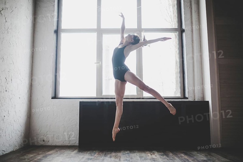 Plasticity slim woman dancing near window. Professional dancer enjoy dance. Lady Dancer Training Modern Ballet In Class. Contemporary dance performer. Daylight, silhouette beautiful body. Dance theme