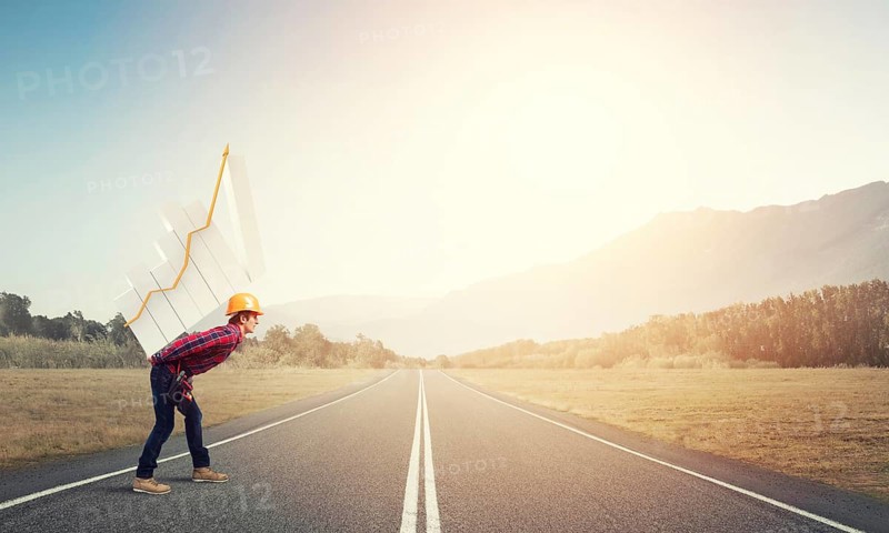 Young man builder carrying growing graph on his back
