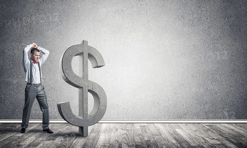 Young furious businessman going to crash with hands stone dollar symbol