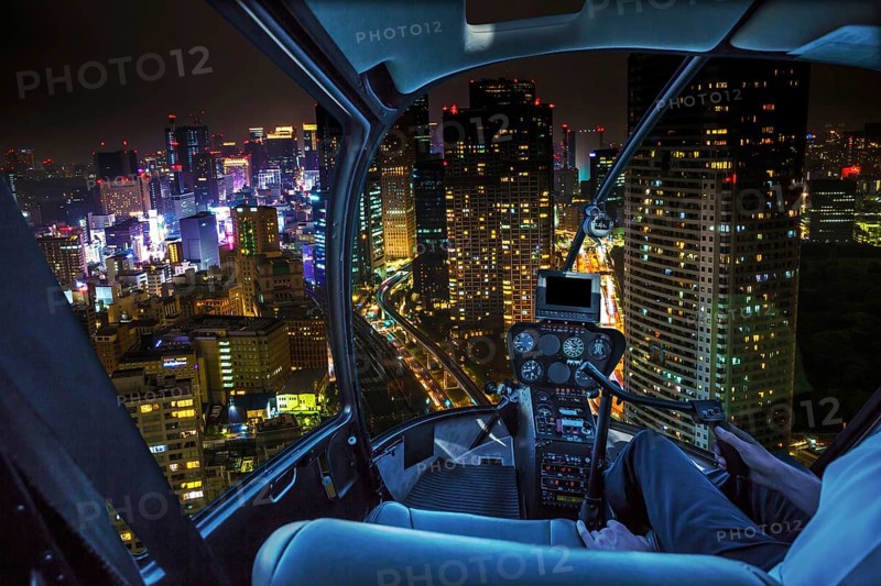 Helicopter flying over Tokyo cityscape and Shiodome skyscrapers and business offices view from skyline at night, Tokyo, Japan