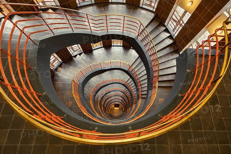 Detailed spiral staircase with orange-coloured banister and tiled floor, fascinating and artistic, Kontorhausviertel, Old Town Hamburg, Free and Hanseatic City of Hamburg, Germany