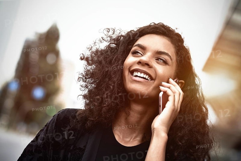 Happy beautiful woman walking and writing or reading sms messages