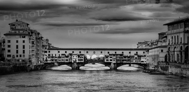 Beautiful black and white photo of the Ponte Vecchio, a medieval stone arch bridge over the Arno River, in Florence, Italy