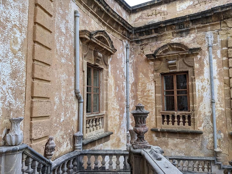 Weathered walls and ornate architectural details with classical windows and stone railing, Villa Palagonia, known as the ‘villa of monsters', is an 18th-century walled building located in Bagheria, Sicily