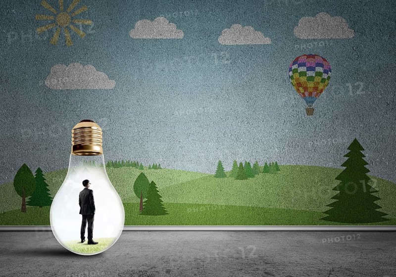 Businessman inside light bulb in room against nature drawn concept