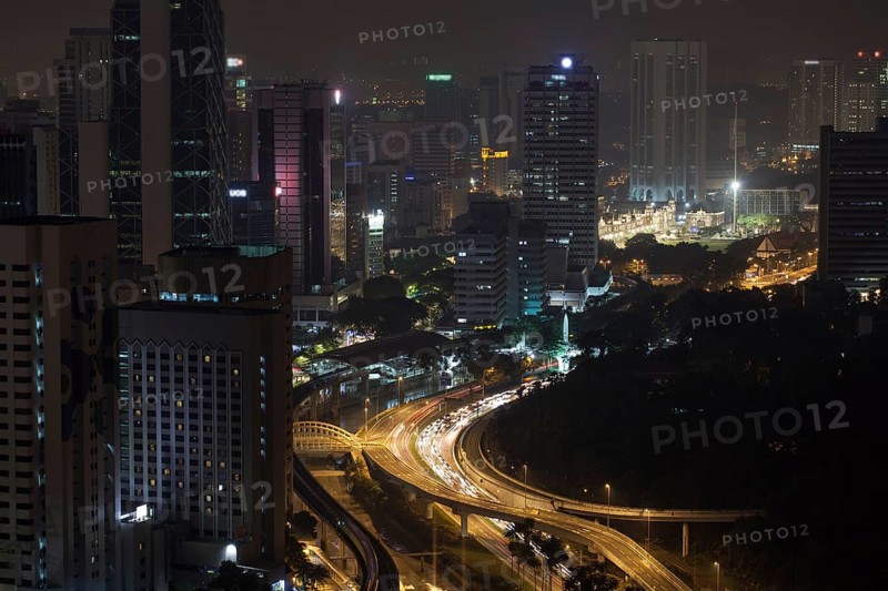Night Kuala Lumpur, Malaysia. City architecture, train and car traffic on illuminated roads