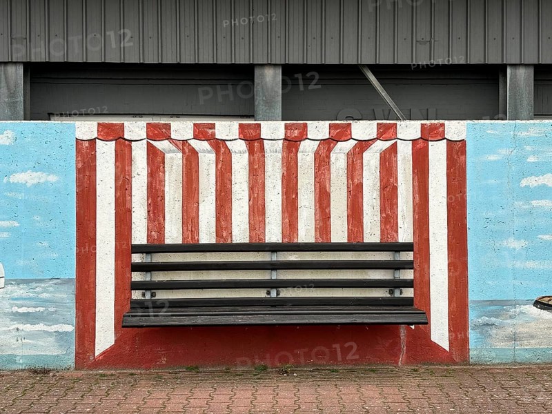Bench with mural on a wall in the harbour, depicting a beach chair, Norderney