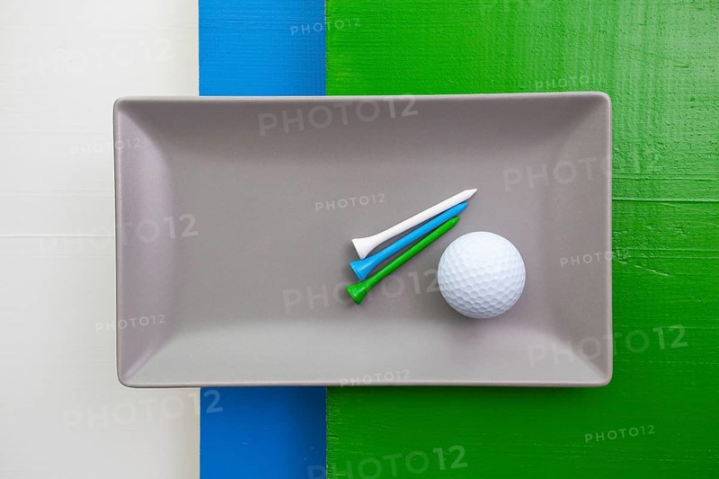 Gray ceramic dish with golf equipments on over white, blue and green wooden table, rectangle dish