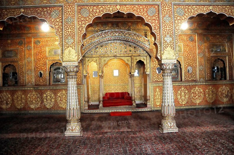 City palace in the fort of Jaisalmer, Rajasthan, India, Asia, A splendidly decorated room with columns and a red sofa in shades of gold, North India
