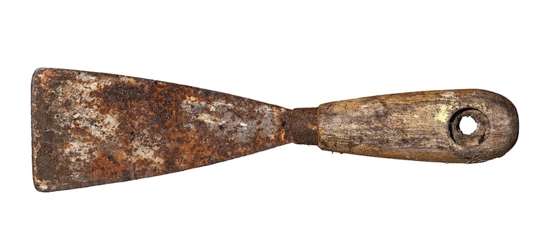 An old rusty and dirty putty knife isolated