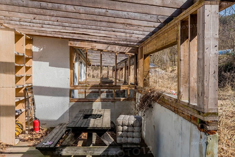 Chungju, South Korea, March 20, 2020: Back patio with decaying wooden picnic table at abandoned resort